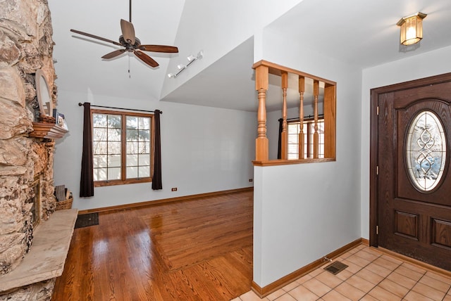 entrance foyer with a fireplace, a ceiling fan, visible vents, and a healthy amount of sunlight