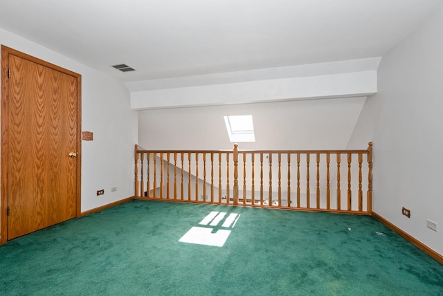 carpeted spare room featuring a skylight, baseboards, and visible vents