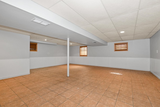 basement with recessed lighting, visible vents, a paneled ceiling, and wainscoting