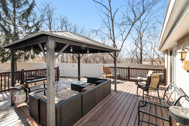 wooden terrace with a gazebo, outdoor lounge area, and a fenced backyard