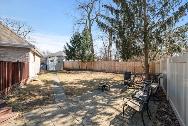 view of patio with an outdoor structure, a storage unit, a fenced backyard, and an outdoor fire pit