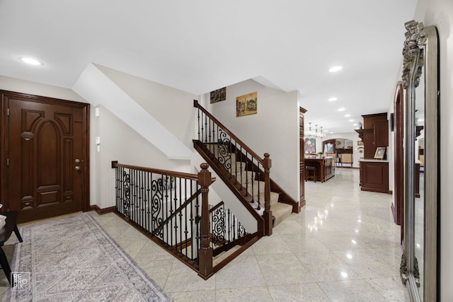 stairs featuring recessed lighting, granite finish floor, arched walkways, and baseboards