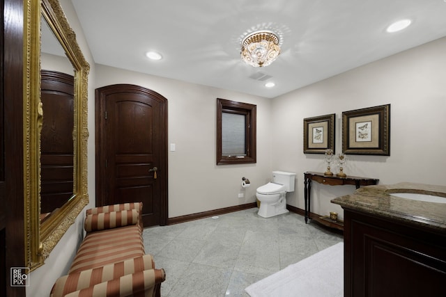 bathroom with toilet, recessed lighting, baseboards, and vanity