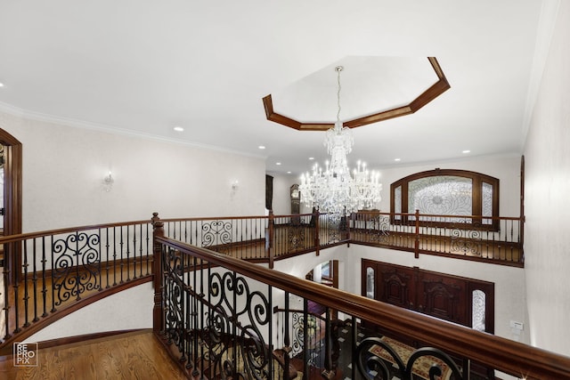 hallway featuring crown molding, wood finished floors, and a notable chandelier