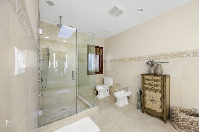 bathroom with a bidet, toilet, visible vents, tile walls, and a stall shower