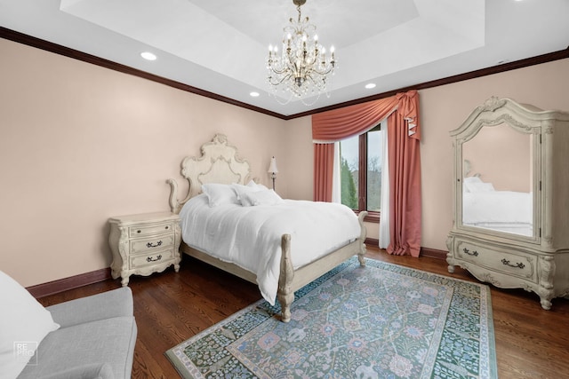 bedroom with wood finished floors, baseboards, an inviting chandelier, a raised ceiling, and crown molding