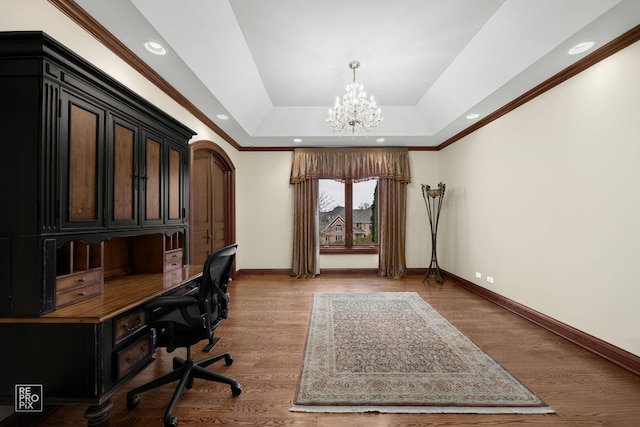 office featuring light wood-style floors, baseboards, a raised ceiling, and a chandelier