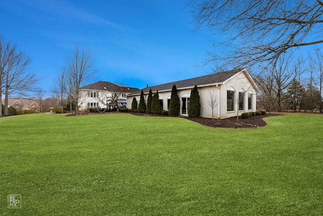 back of property featuring brick siding and a yard