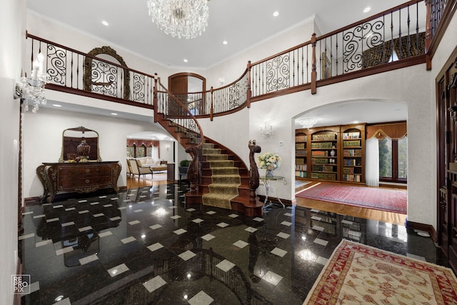 foyer entrance with baseboards, granite finish floor, arched walkways, and crown molding