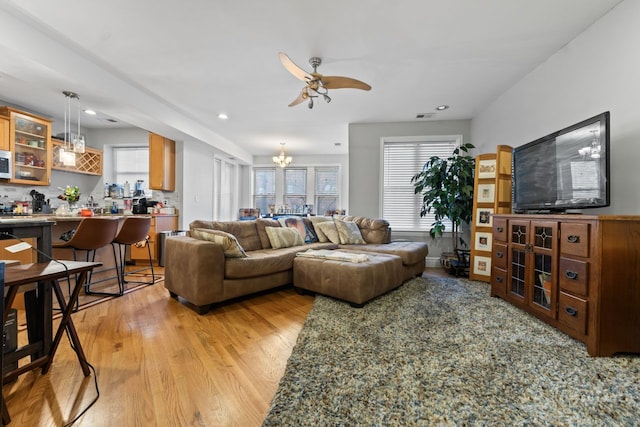 living area featuring light wood finished floors, visible vents, a wealth of natural light, and recessed lighting