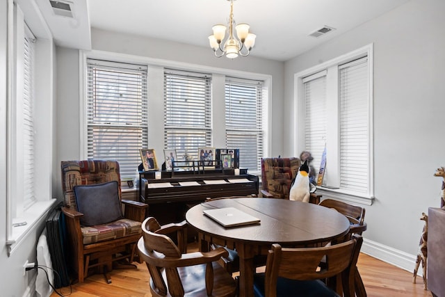 dining space featuring a chandelier, visible vents, and light wood-style flooring