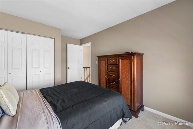 bedroom with light colored carpet, a closet, and baseboards