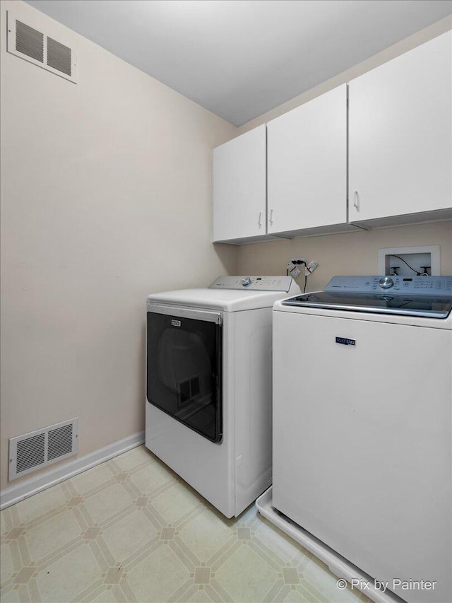 laundry room with cabinet space, visible vents, light floors, and washing machine and clothes dryer