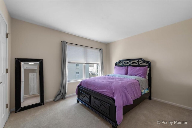 bedroom with baseboards and light colored carpet