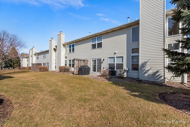 rear view of property with a lawn and a chimney