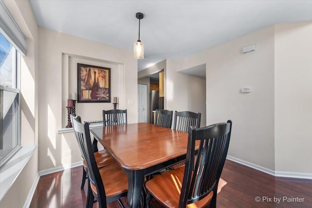 dining area featuring baseboards and dark wood finished floors