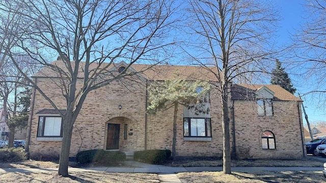 view of front facade featuring a chimney and brick siding