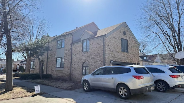 view of side of property with driveway and brick siding