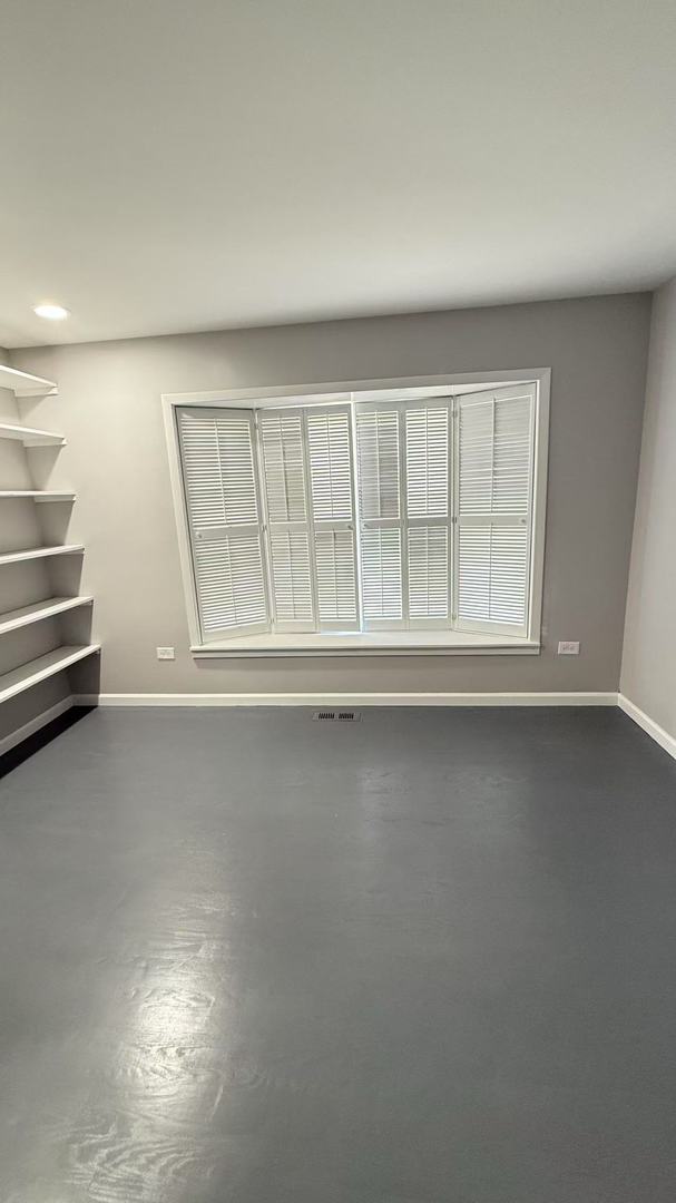 empty room with baseboards, visible vents, and finished concrete floors