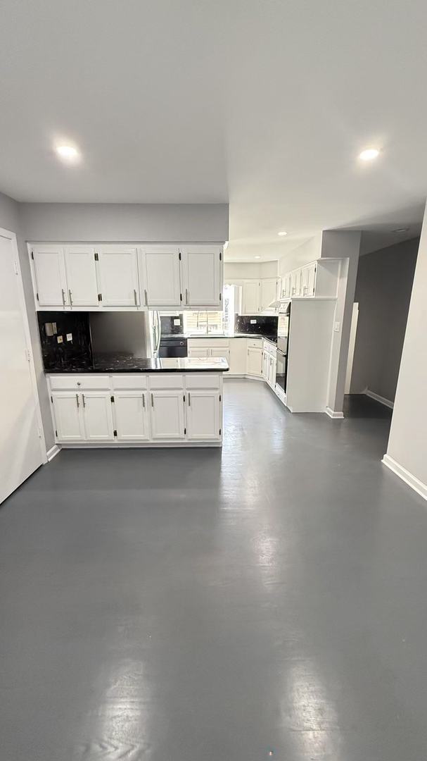 kitchen featuring tasteful backsplash, baseboards, concrete floors, white cabinetry, and recessed lighting