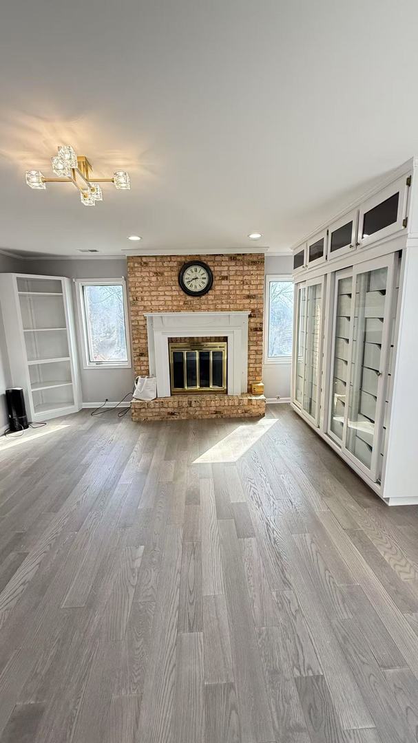 unfurnished living room featuring a fireplace, baseboards, wood finished floors, and recessed lighting