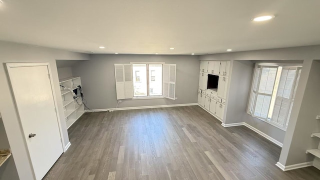 unfurnished living room with recessed lighting, dark wood-style flooring, and baseboards