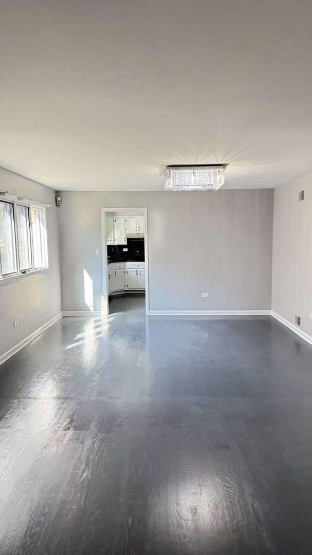 unfurnished living room featuring visible vents and baseboards