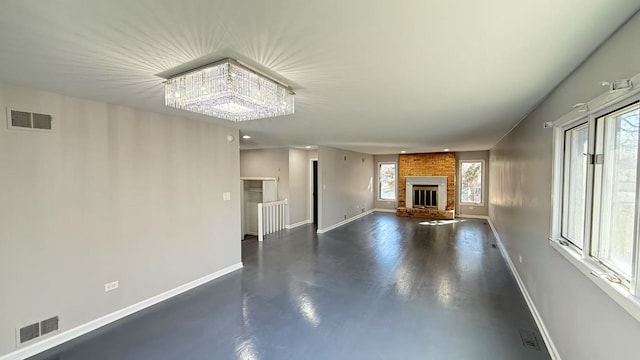 unfurnished living room featuring a brick fireplace, baseboards, and visible vents