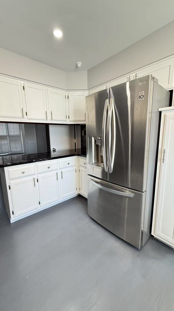 kitchen featuring dark countertops, white cabinets, stainless steel fridge with ice dispenser, and recessed lighting