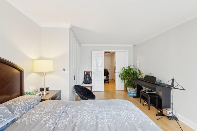 bedroom featuring wood finished floors, baseboards, french doors, and ornamental molding