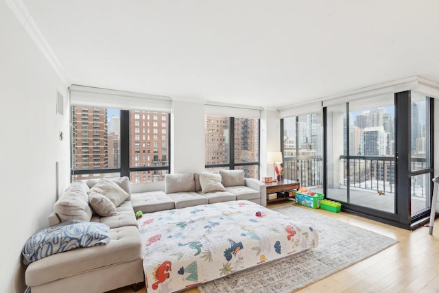 living room with a city view, floor to ceiling windows, wood finished floors, and ornamental molding