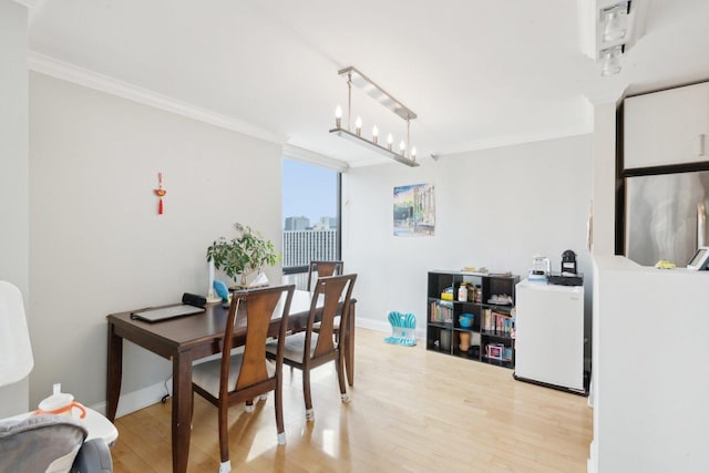 dining room with crown molding, baseboards, and light wood-type flooring