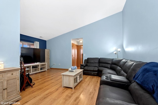 living area with lofted ceiling, light wood-style floors, and baseboards