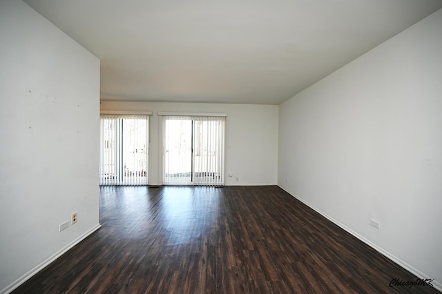 spare room featuring baseboards and wood finished floors