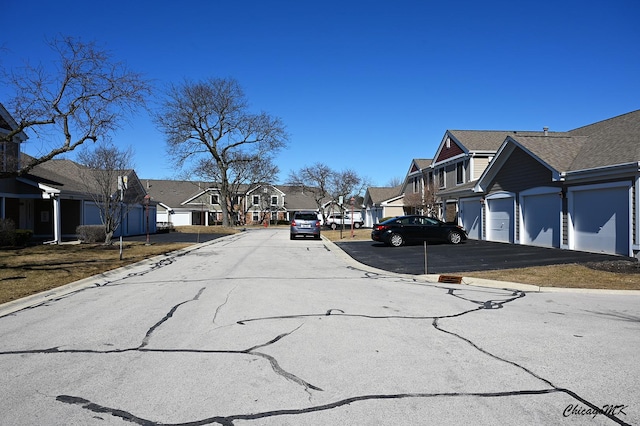 view of road featuring a residential view, curbs, and community garages