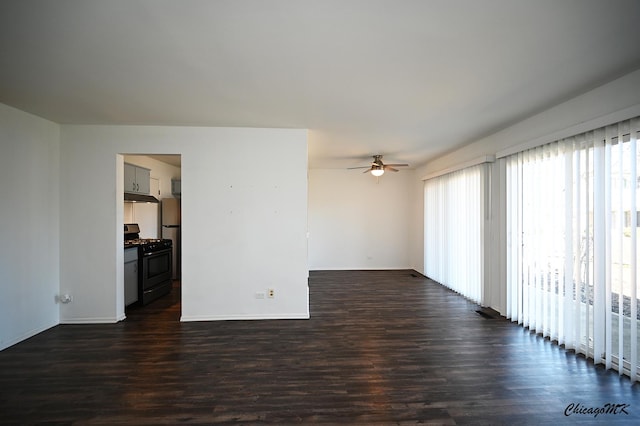 spare room with dark wood-style floors, baseboards, and a ceiling fan