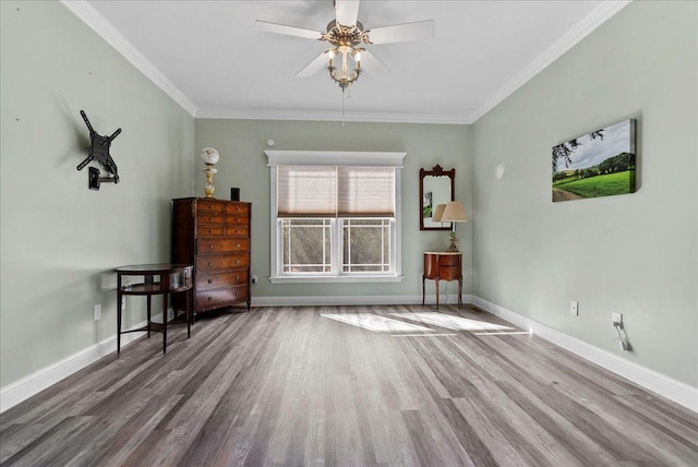 spare room with ceiling fan, baseboards, wood finished floors, and crown molding