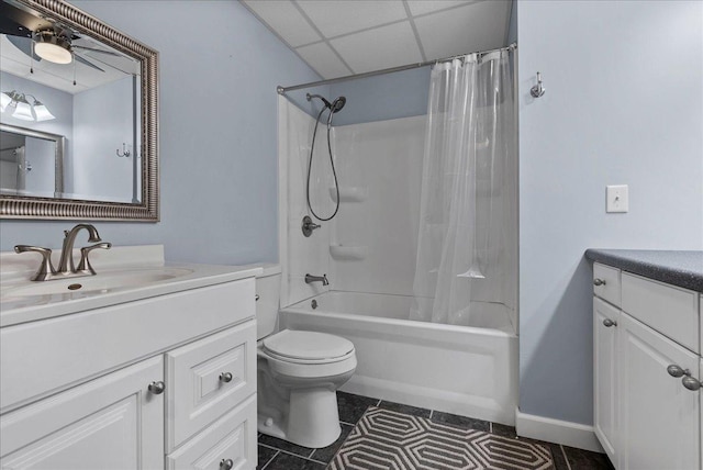 full bathroom featuring vanity, shower / bathtub combination with curtain, a drop ceiling, tile patterned flooring, and toilet