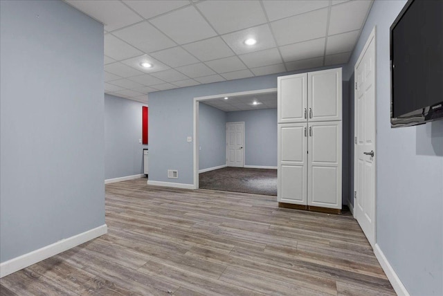 interior space with recessed lighting, light wood-type flooring, baseboards, and a paneled ceiling