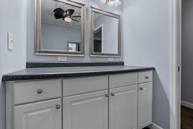 bathroom with baseboards, vanity, and a ceiling fan