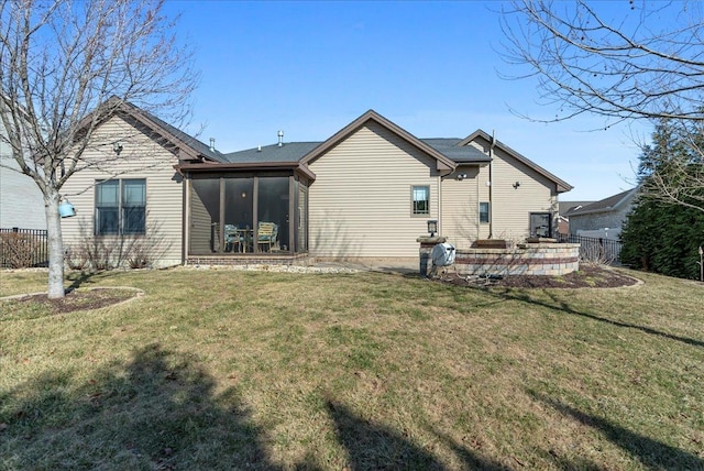 rear view of property with a patio area, fence, a yard, and a sunroom