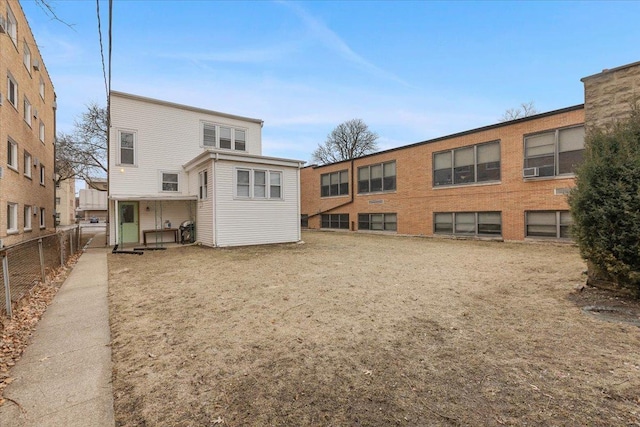 rear view of property featuring fence