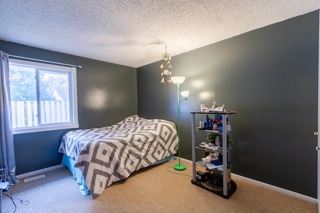 bedroom featuring carpet, visible vents, a textured ceiling, and baseboards