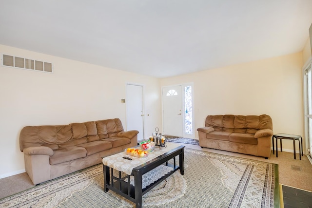 carpeted living room featuring visible vents and baseboards