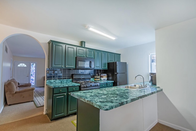 kitchen featuring arched walkways, a peninsula, a sink, backsplash, and black appliances