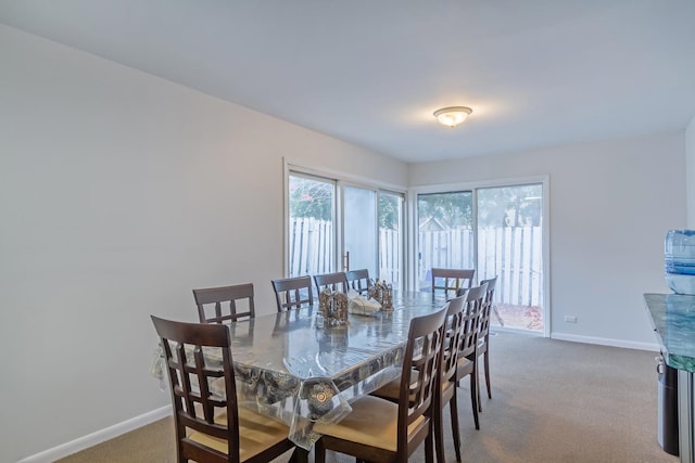 carpeted dining space with baseboards