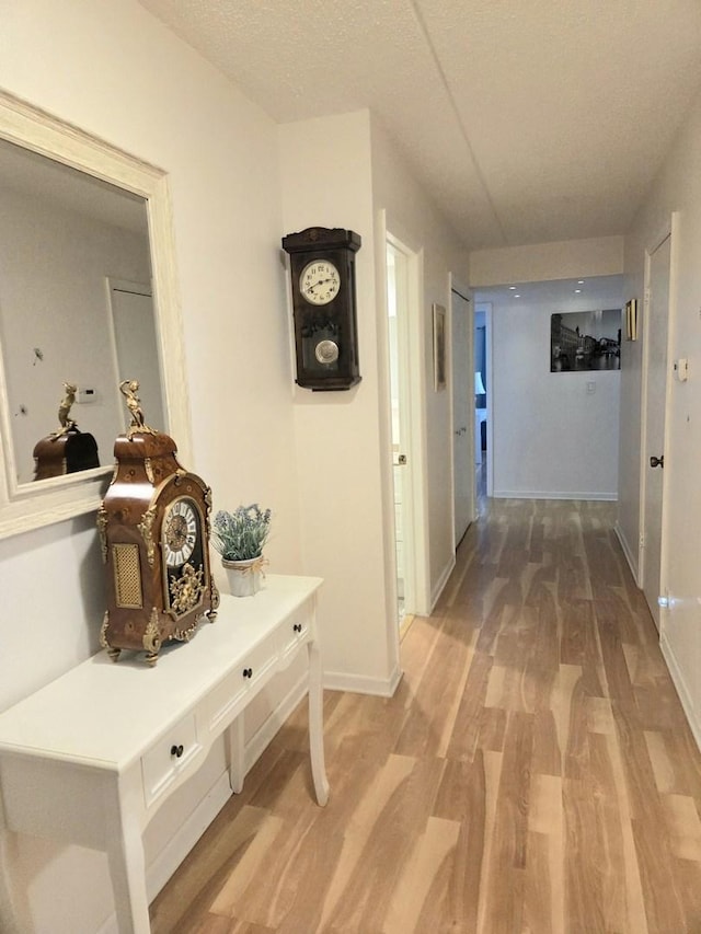 hallway with light wood-style flooring and baseboards