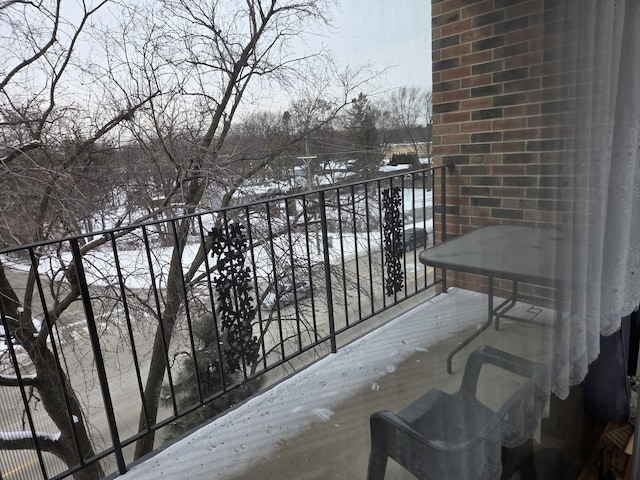 view of snow covered back of property