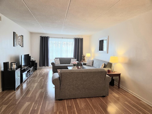 living room featuring a textured ceiling, baseboards, and wood finished floors