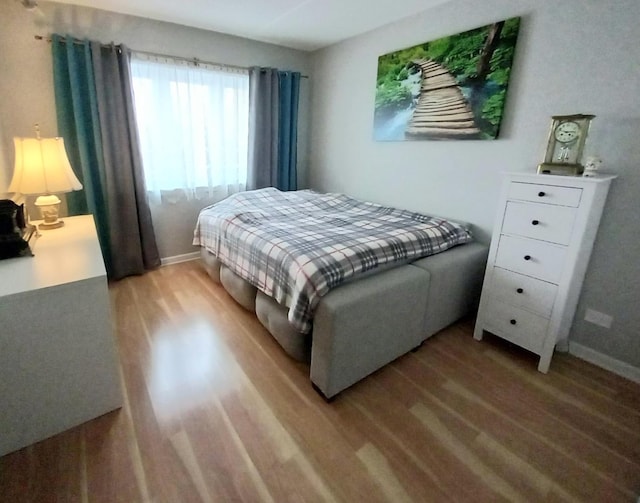 bedroom with baseboards and wood finished floors